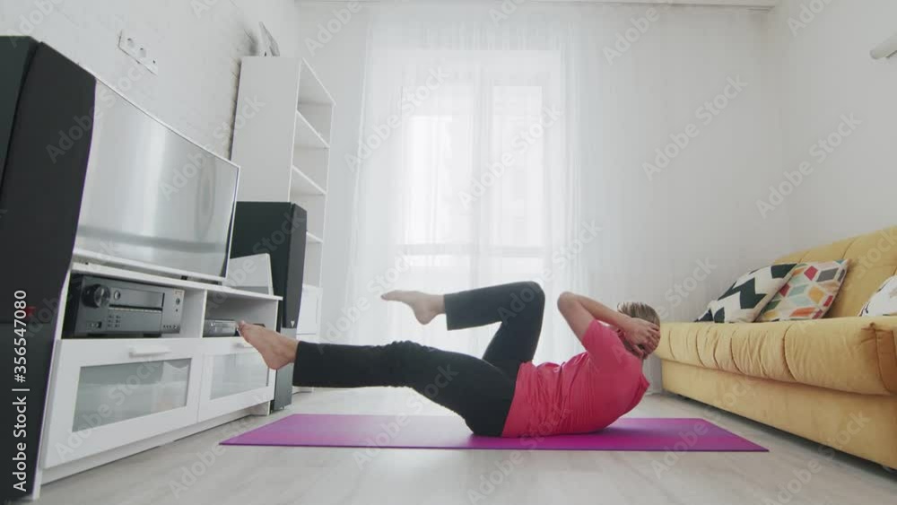 Young transgender homosexual man with make up doing abs crunch exercise on mat at home Young transgender homosexual man with make up doing abs crunch exercise on mat at home