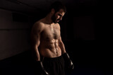  Boxer in boxing gloves on a black background after training