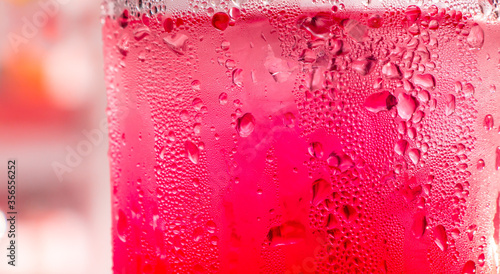 red soda water splashing with bubbles close up and Dew Point on glass