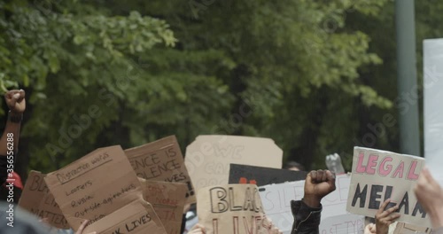 Handheld slow motion shot of signs and placards in global protest against police brutality, in Oslo Norway