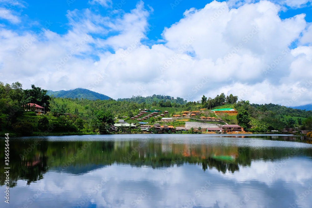 An Asian hill village with a lake landscape and blue sky background