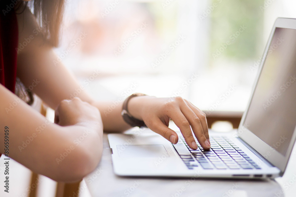 Female hands typing on laptop in cafe blurred background. Female hands typing on laptop in cafe blurred background.