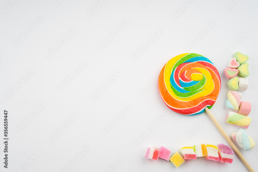 Abstract arrangement of candies and sweets on multi colored background