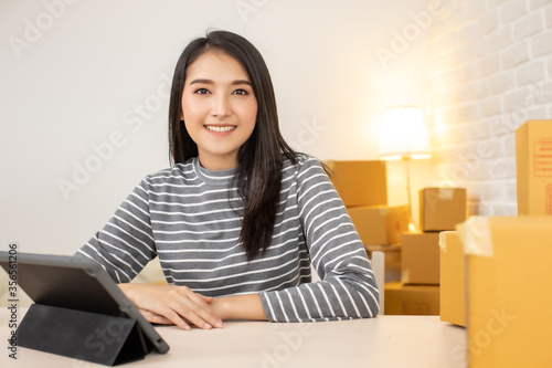 Worker In Warehouse Checking Boxes Using Digital Tablet.Start up small business entrepreneur SME or freelance man and woman working at home concept, Young Asian small business owner,online marketing.