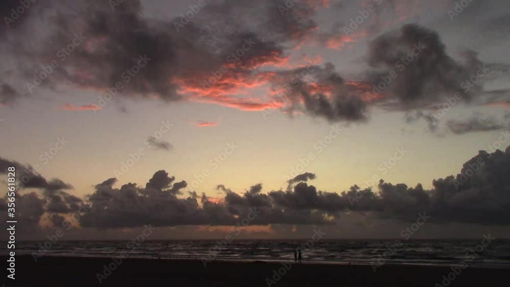 A couple enjoy the sunrise on a deserted Gulf of Mexico beach in Texas A couple enjoy the sunrise on a deserted Gulf of Mexico beach in Texas
