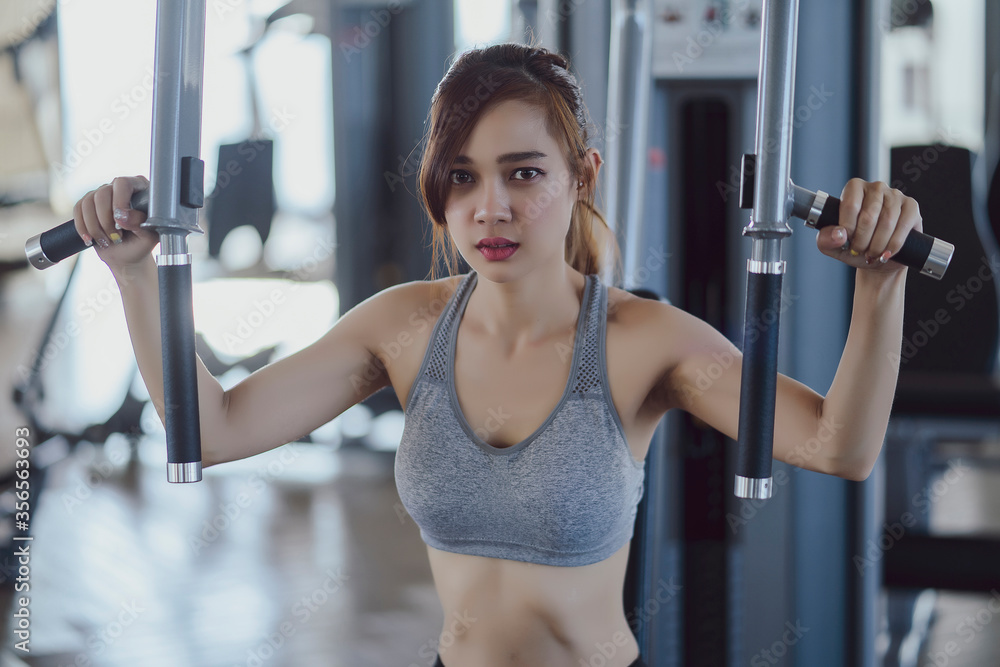 fitness new normal, Woman at the gym on a sports simulator., Fit beautiful young woman exercise workout on machine in gym. Glad smiling girl is enjoy with her training process. Concept of fitness, Hea fitness new normal, Woman at the gym on a sports simulator., Fit beautiful young woman exercise workout on machine in gym. Glad smiling girl is enjoy with her training process. Concept of fitness, Hea