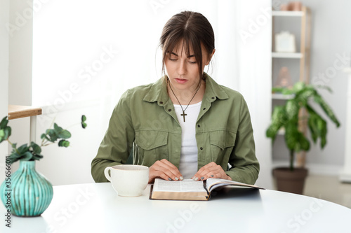 Young woman reading Bible a...