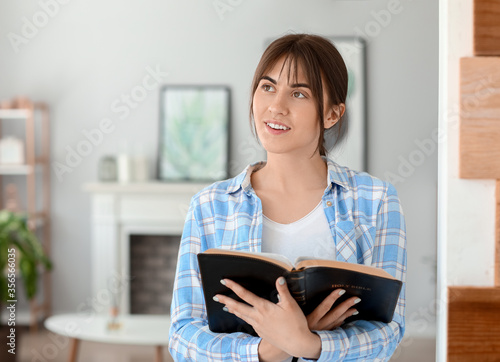 Young woman with Bible at home