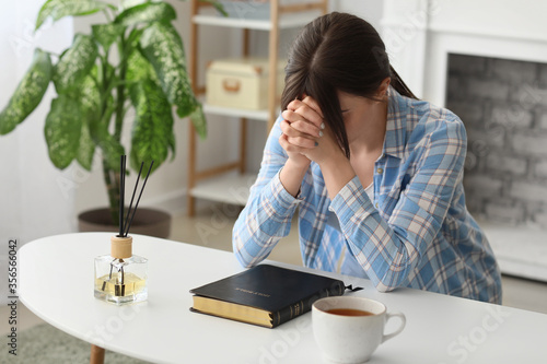Young woman with Bible pray...