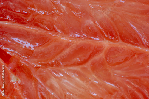 Sliced red grapefruit texture macro close up background