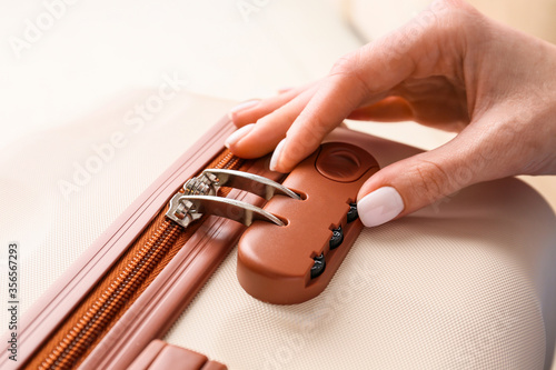 Obraz na płótnie Woman opening lock on suitcase, closeup