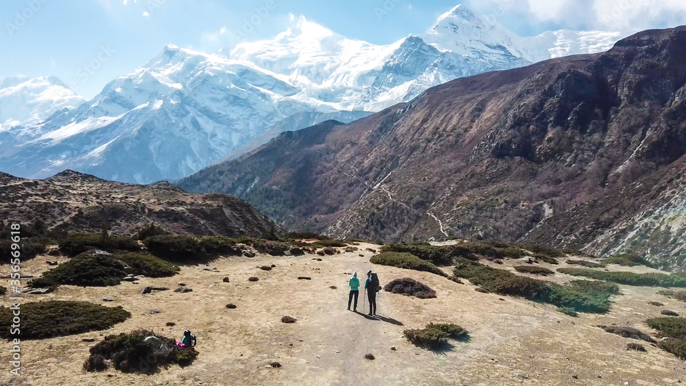 Φωτογραφία A couple trekking in the Manang Valley, Annapurna Circus Trek, Himalayas, Nepal, with the view on Annapurna Chain and Gangapurna