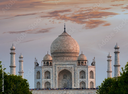 Tourist gather at the Taj Mahal with pale purple sunset