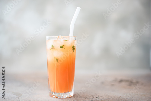 freshly squeezed grapefruit juice with ice in a tall glass