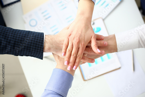 Group of people in suits crossed hands in pile for win closeup. White collar leadership high five cooperation initiative achievement corporate life style friendship dea, heap stack concept