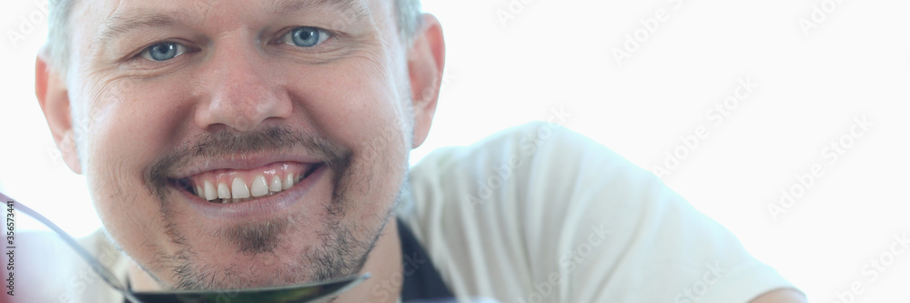 Fototapeta premium Smiling Culinary Recipe Chef Blogger Portrait. Happy Man Holding Kitchen Spoon. Cook with Kitchenware. Professional Food Blog at Home. Male Cooking Lifestyle Horizontal Looking at Camera Shot