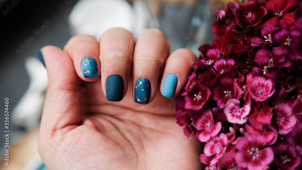 Naklejka premium Women's hands with colorful patterns on the nails. Summer colors trend. Top view. The place for text.