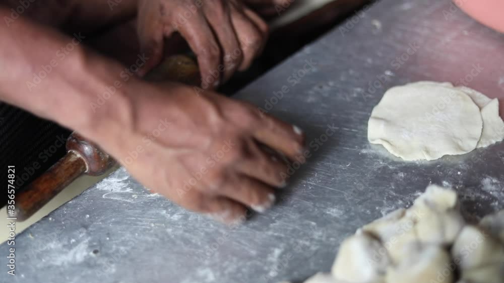 Kneading Indian bread dough for momos or samosa using a belan. Kneading Indian bread dough for momos or samosa using a belan.
