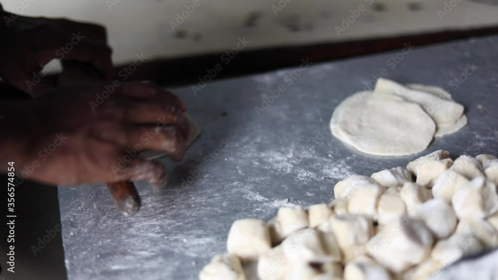 Kneading Indian bread dough for momos or samosa using a belan. Kneading Indian bread dough for momos or samosa using a belan.