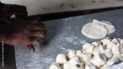 Kneading Indian bread dough for momos or samosa using a belan. photo