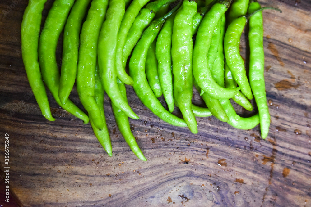 fresh green chilies on chopping board for spicy vegetable fresh green chilies on chopping board for spicy vegetable