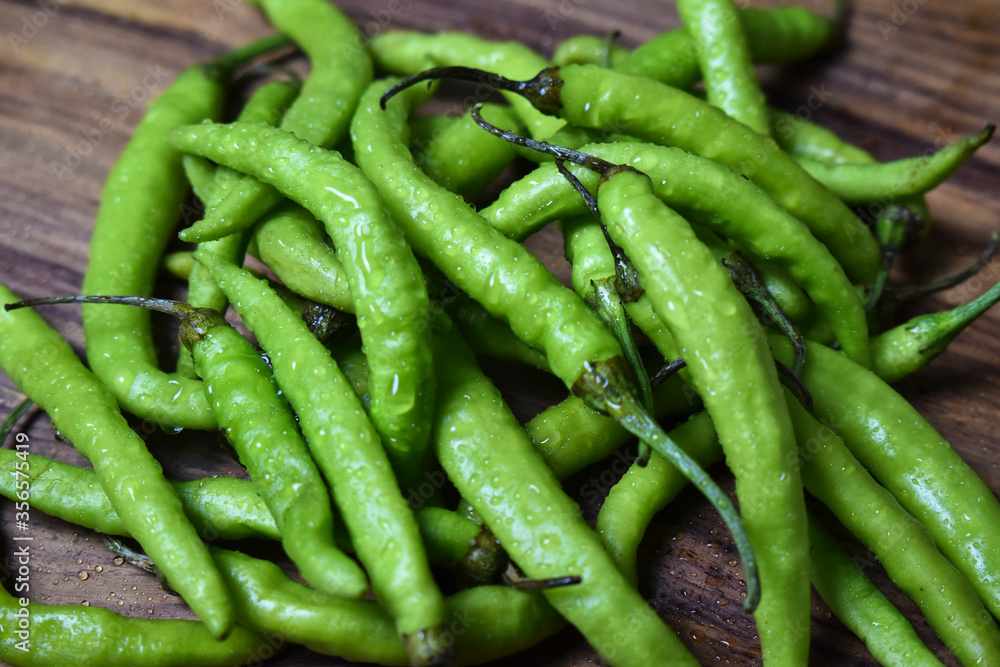 fresh green chilies on chopping board for spicy vegetable fresh green chilies on chopping board for spicy vegetable