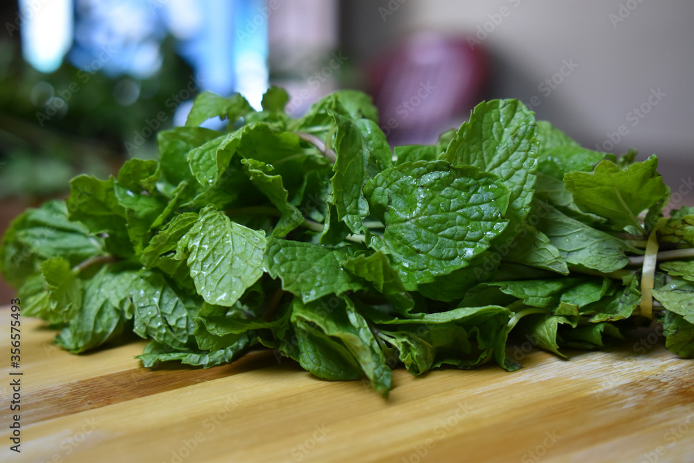 fresh mint leaves on wooden chopping board fresh mint leaves on wooden chopping board