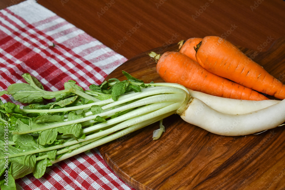 fresh radish and carrot on wooden chopping board