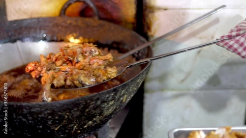 Deep frying chicken in an India Kadhai at a street food market in Zakir Nagar, Delhi photo