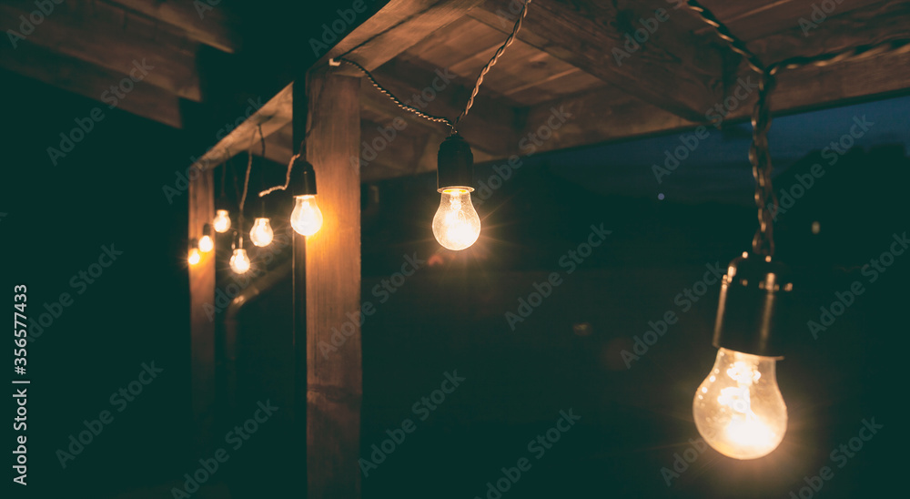 The garland of  light bulbs hanging on the wooden terrace