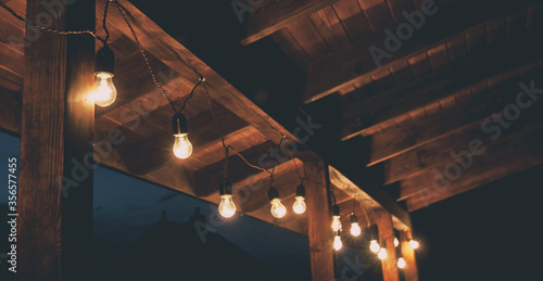 The garland of  light bulbs hanging on the wooden terrace