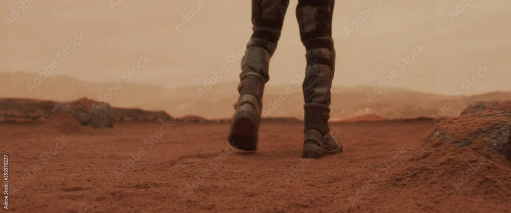 CU astronaut walking towards a cliff while exploring Mars planet surface. Colonization concept. Shot on ARRI Alexa Mini