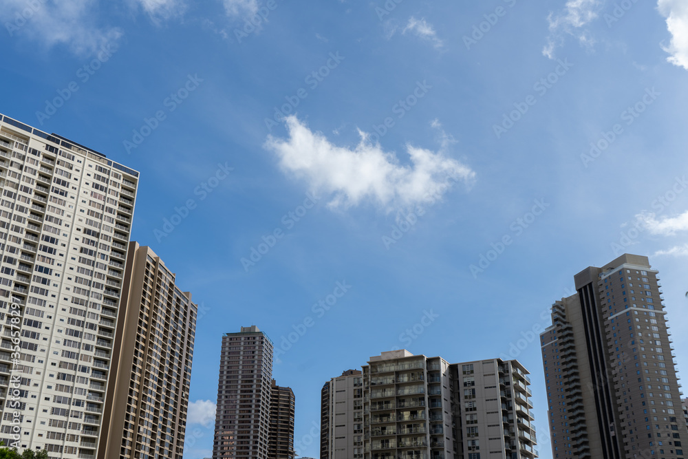 Blue sky with clouds and tall building in the city of Honolulu, Hawaii USA