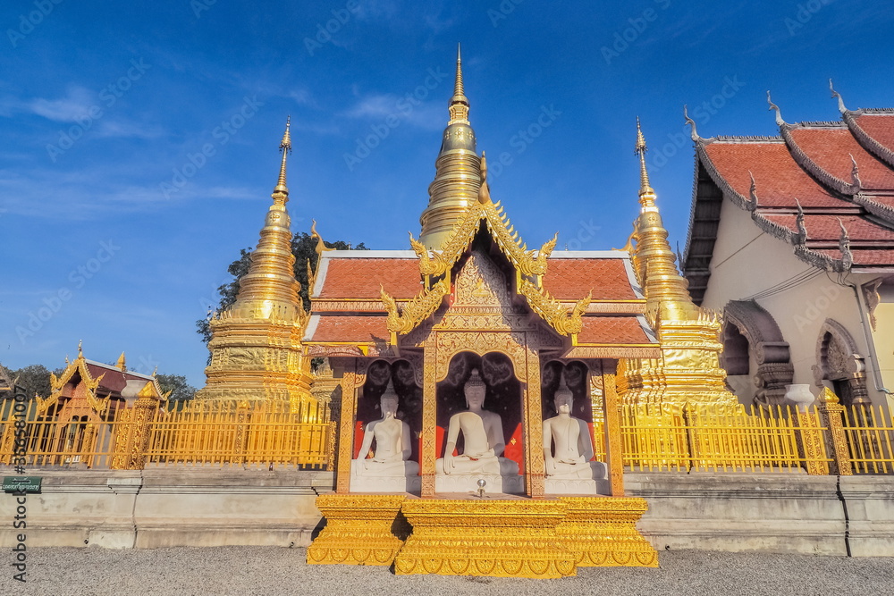 view of Golden Pagoda (Stupa, Chedi) with buddhist temple lanna style art and blue sky background, Wat Phra That Ha Duang, Li District, Lamphun, northern of Thailand. view of Golden Pagoda (Stupa, Chedi) with buddhist temple lanna style art and blue sky background, Wat Phra That Ha Duang, Li District, Lamphun, northern of Thailand.