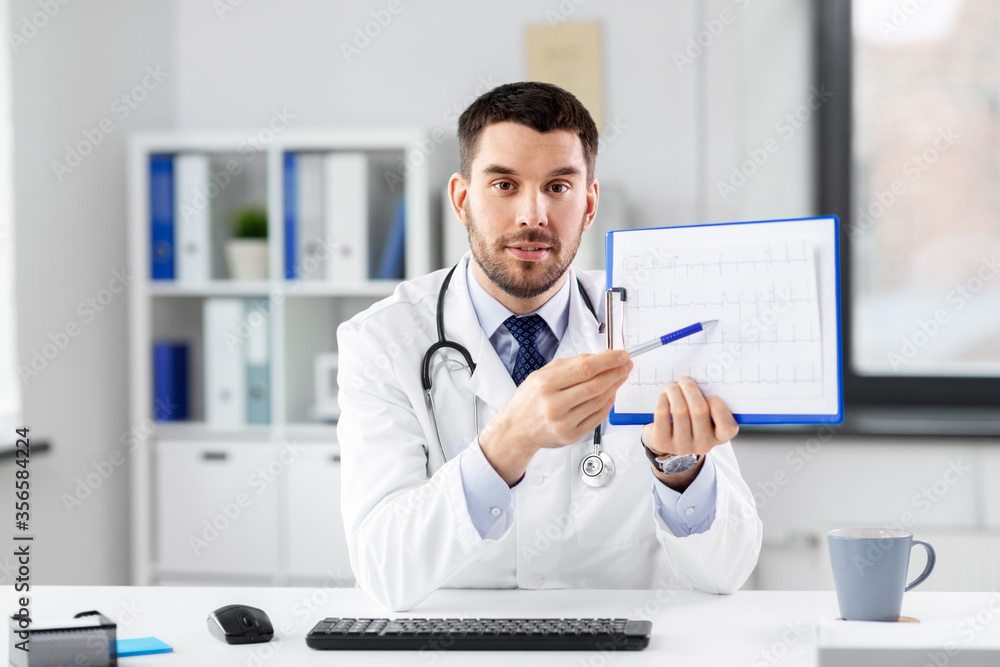 Obraz premium healthcare, medicine and people concept - male doctor with cardiogram on clipboard having video conference at hospital