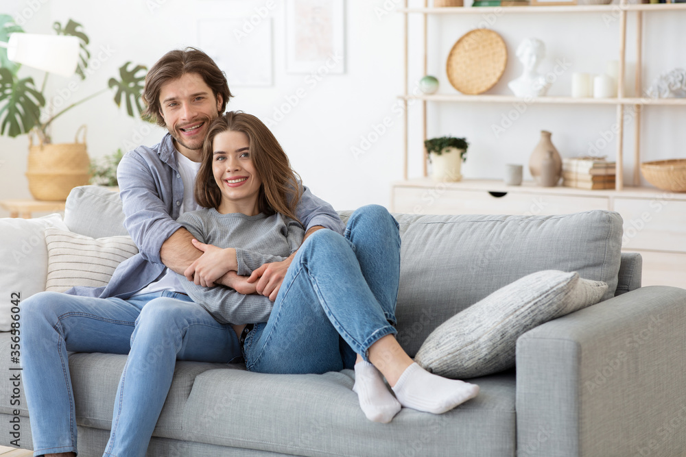 Young beautiful couple posing on couch at home