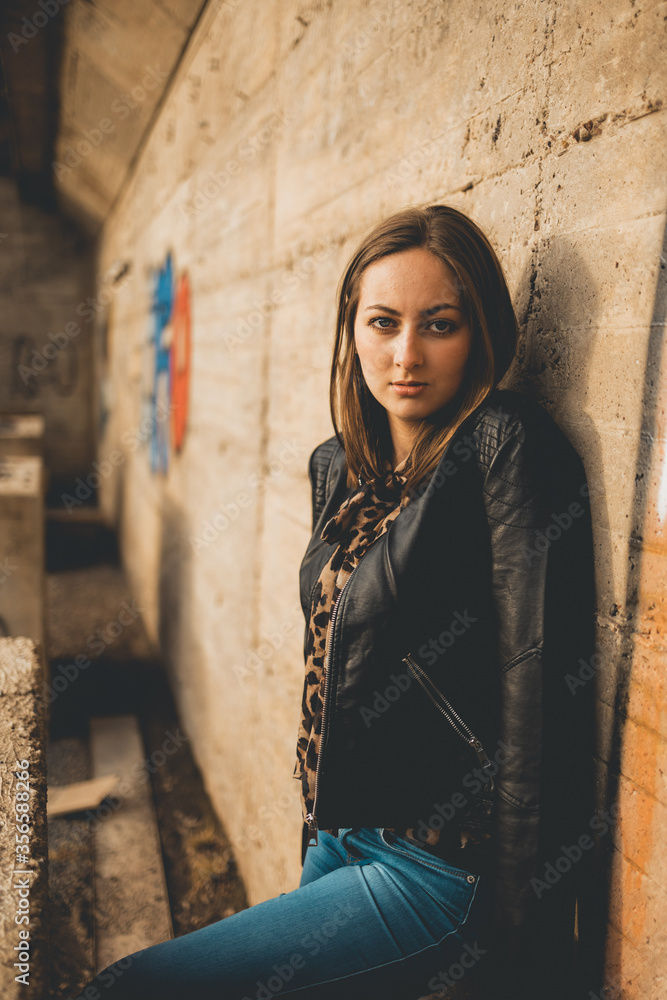 Junge Frau in Lederjacke und Jeans posiert in einem Lost Place Junge Frau in Lederjacke und Jeans posiert in einem Lost Place