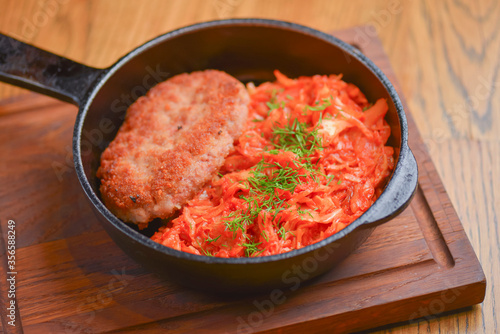 Fried chicken meat in frying pan with vegetable stew. Traditional Ukrainian cuisine, tasty dish. Delicious dinner.