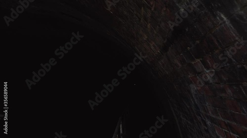 Dark brickwork lining of an old canal tunnel in Dudley photo