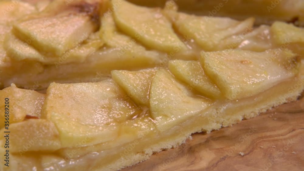 Delicious homemade french apple pie slices lay on the wooden board