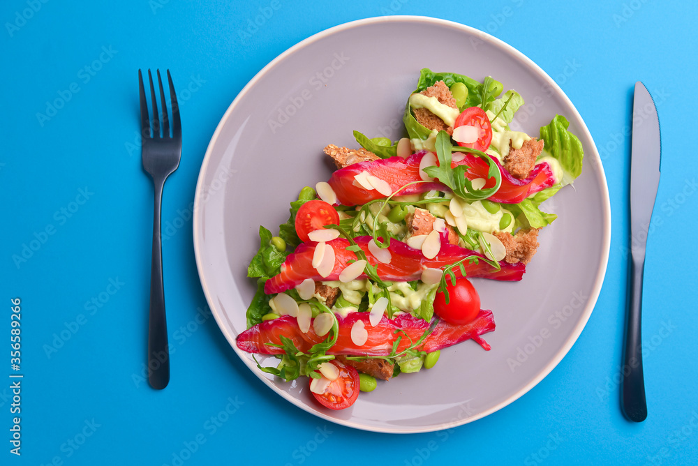 Fresh salad with smoked salted salmon, tomatoes and pumpkin seeds. Served on a gray plate over gray texture background. Fresh salad with smoked salted salmon, tomatoes and pumpkin seeds. Served on a gray plate over gray texture background.