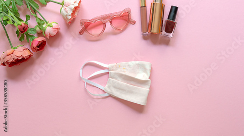 Summer concept. Flat lay with trendy mask, glasses, and feminine accessories on a pink background. Copy space