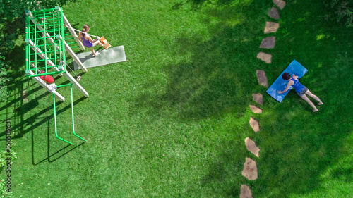 Family fitness and sport outdoor workout in park, aerial view of girls exercising on garden grass from above
