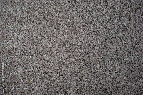 Gray doormat which is made from synthetic fibers.
