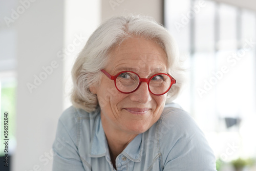Smiling senior woman with red eyeglasses