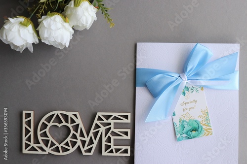 
card and bouquet of white roses on a gray background