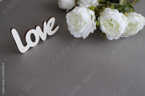 
White flowers on a gray background and the inscription 