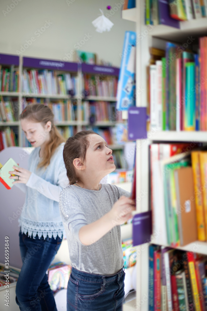 girl in library choosing books. girl in library choosing books.