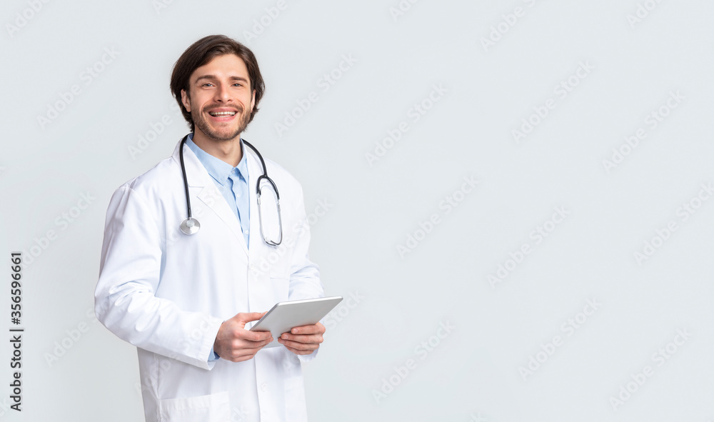 Cheerful medical doctor holding digital tablet in hands Cheerful medical doctor holding digital tablet in hands