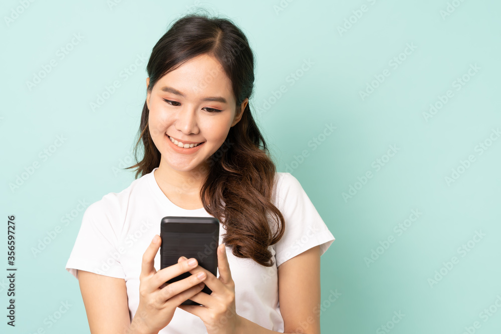 Portrait of young asian woman using mobile with happy on green background. Portrait of young asian woman using mobile with happy on green background.